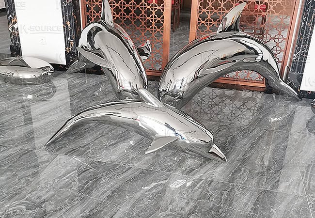 A diving sculpture of three dolphins
