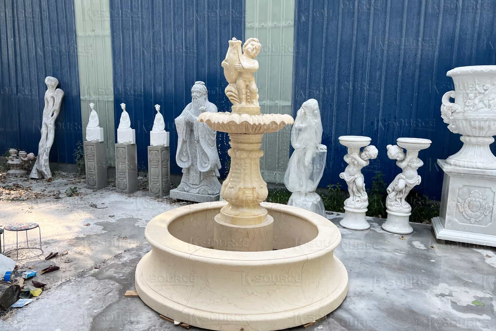 child holding fish stone fountain