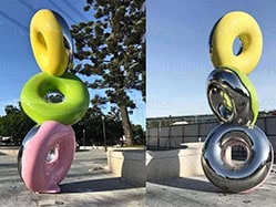 Three donuts stacked on top of each other create a giant donut sculpture.