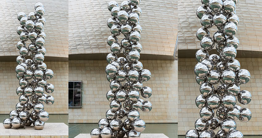 The mirrored metal sculpture composed of balls of different sizes is very irregular and fashionable.