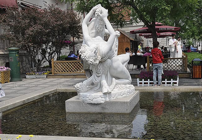 Marble statue of a naked half-man, half-animal man holding a naked woman.