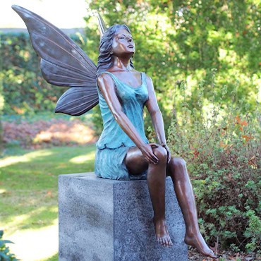 Statue of a Little Girl Angel with Wings in the Garden.
